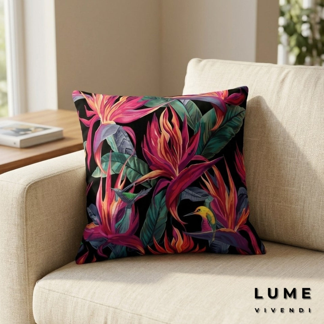 A square throw pillow of the Emotion edition from Birds of Paradise Collection with a vibrant tropical floral print in pink, orange, and green on a black background, styled on a beige fabric sofa. The brand name 'LUME VIVENDI' is visible in the bottom right corner.