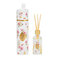 Fleur Pink Reed Diffuser by SoapTales, featuring a clear glass bottle with wooden reeds and a decorative floral cylindrical box in pink, yellow, and lilac hues.