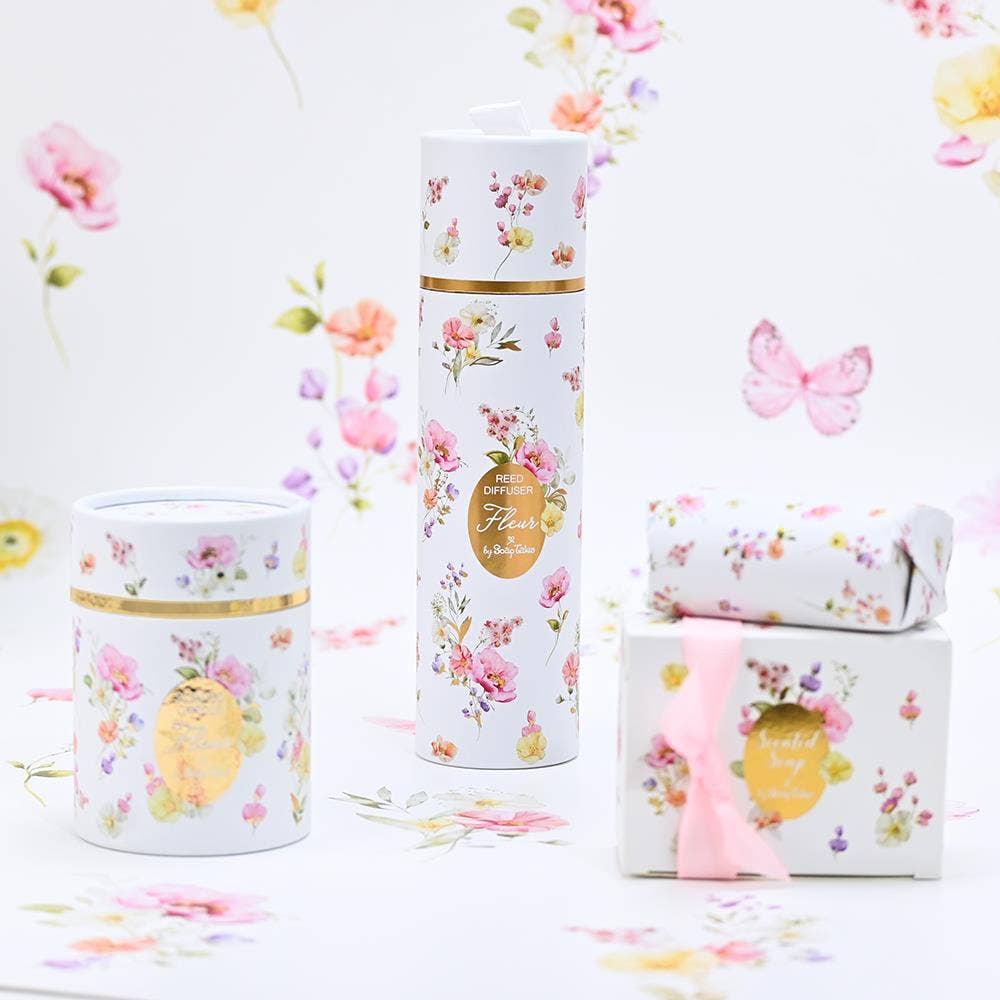 Floral-themed product set including a candle, diffser, and box of soap on a floral background