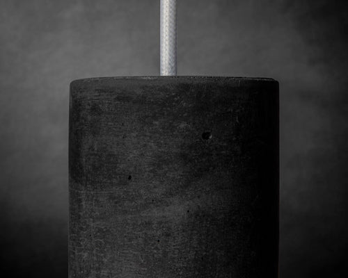 Close-up of a textured black concrete block with a gray background