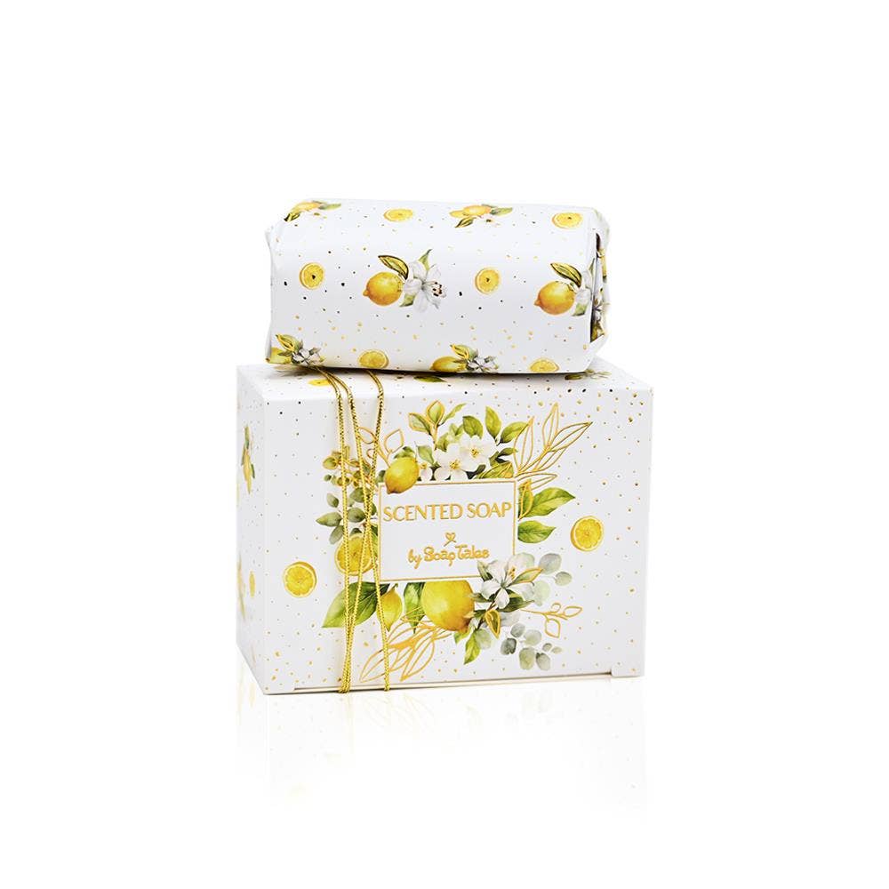 A 100g bar of Lemongrass scented soap by SoapTales, presented in a luxury white box featuring illustrations of lemons and green leaves with gold accents.