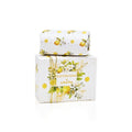 A 100g bar of Lemongrass scented soap by SoapTales, presented in a luxury white box featuring illustrations of lemons and green leaves with gold accents.