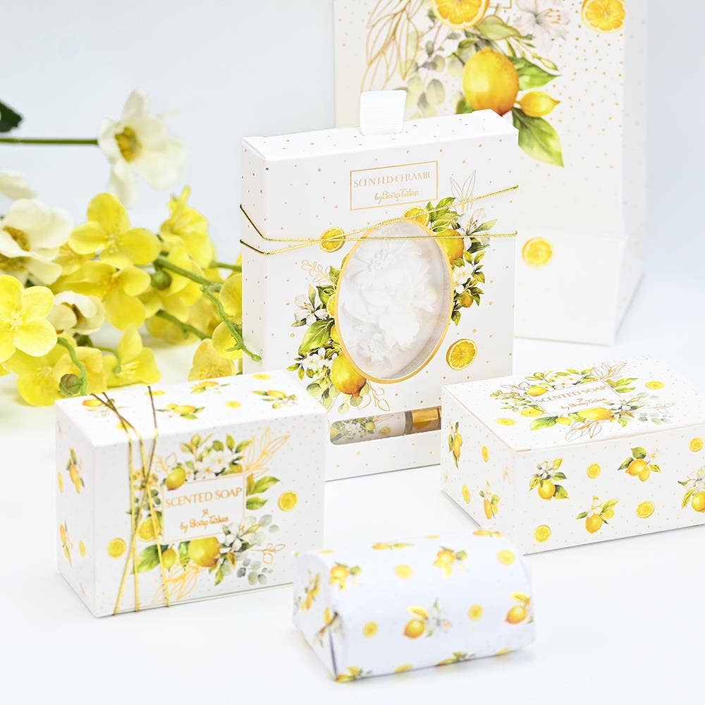 A  Lemongrass scented soap and self care set by SoapTales, presented in a luxury white box featuring illustrations of lemons and green leaves with gold accents.