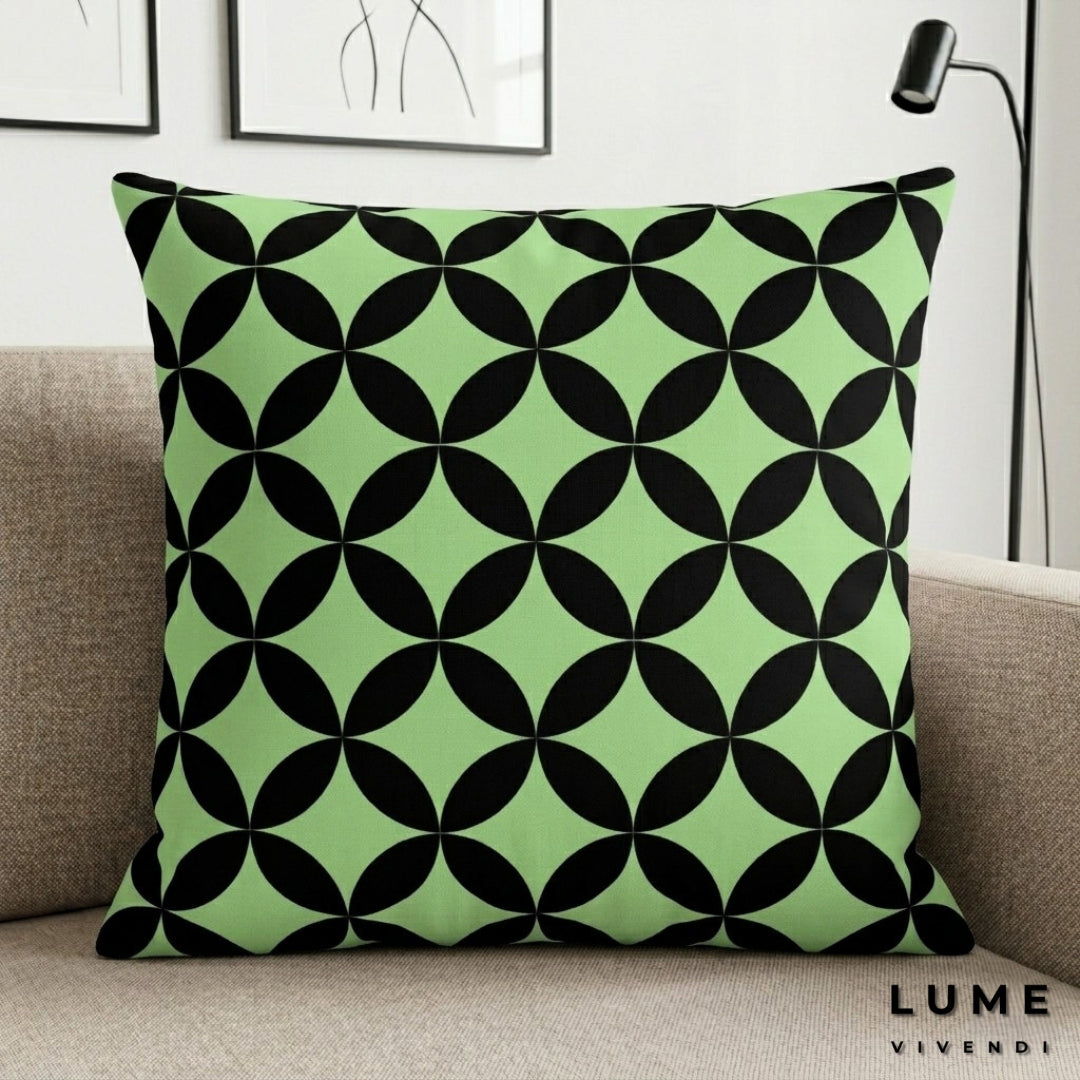 Green pillow with black geometric pattern on a beige couch, featuring the brand 'Lume Vivendi'.