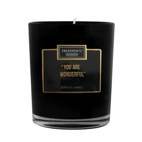 Black candle with gold text on a white background