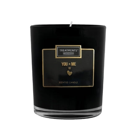 Black scented candle with 'Treatments' label on a white background
